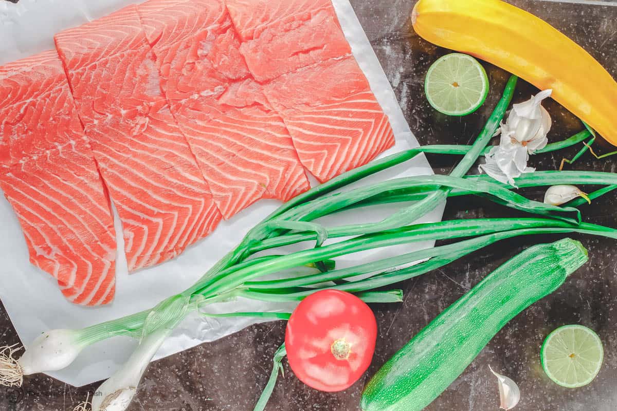 Salmon fillets with green onions, tomato, garlic, zucchini and yellow squash