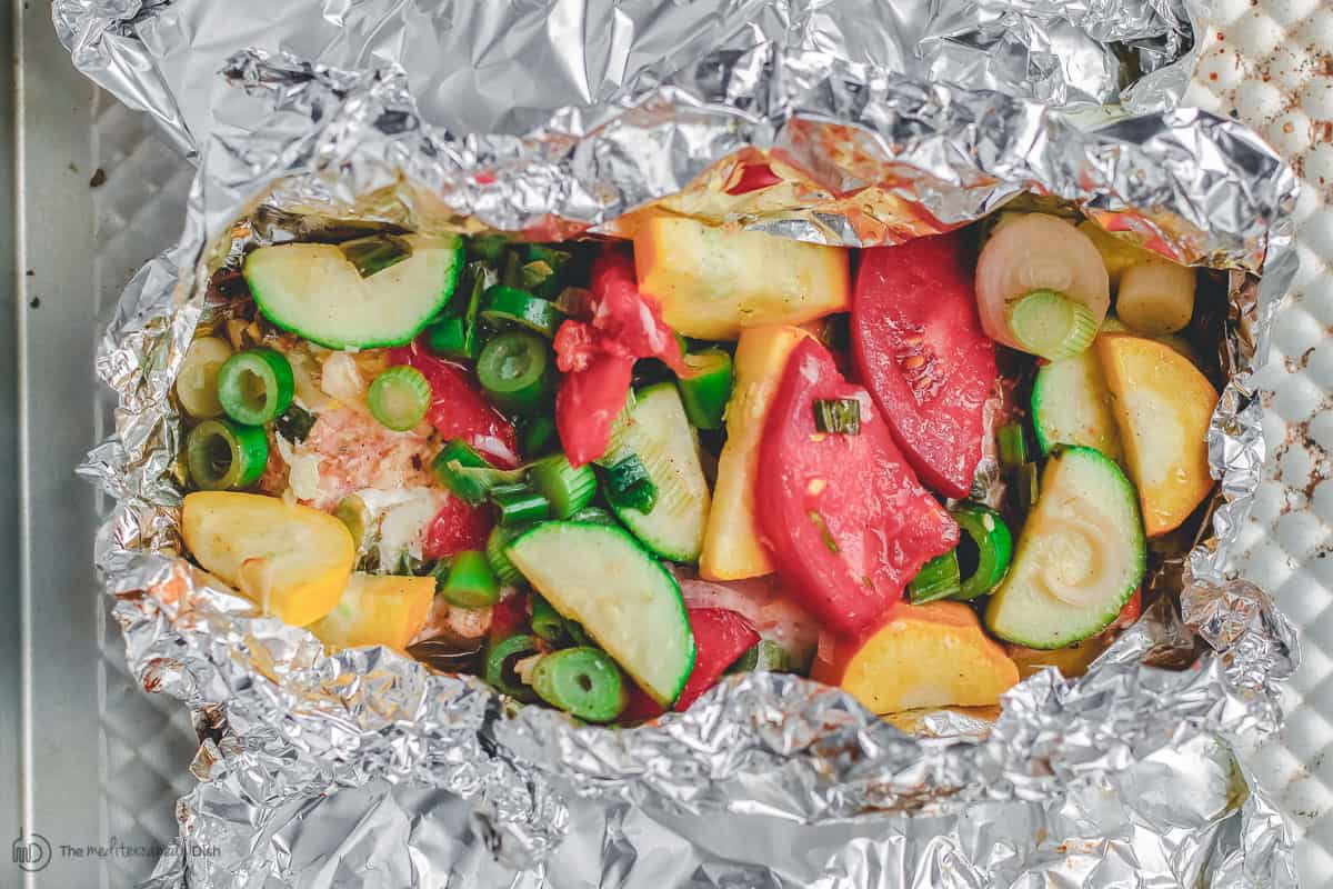 Salmon and vegetables individually wrapped in foil, open-faced