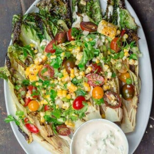 Grilled Lettuce Salad with corn, tomatoes, and a side of tahini sauce