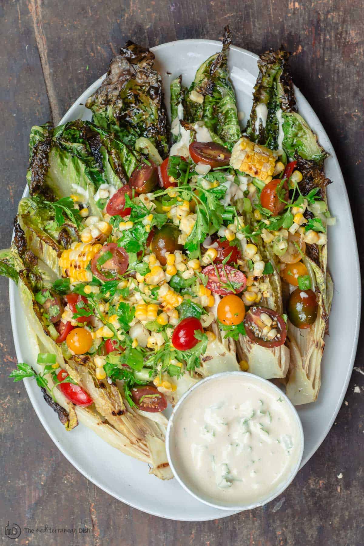 Grilled Lettuce Salad with corn, tomatoes, and a side of tahini sauce