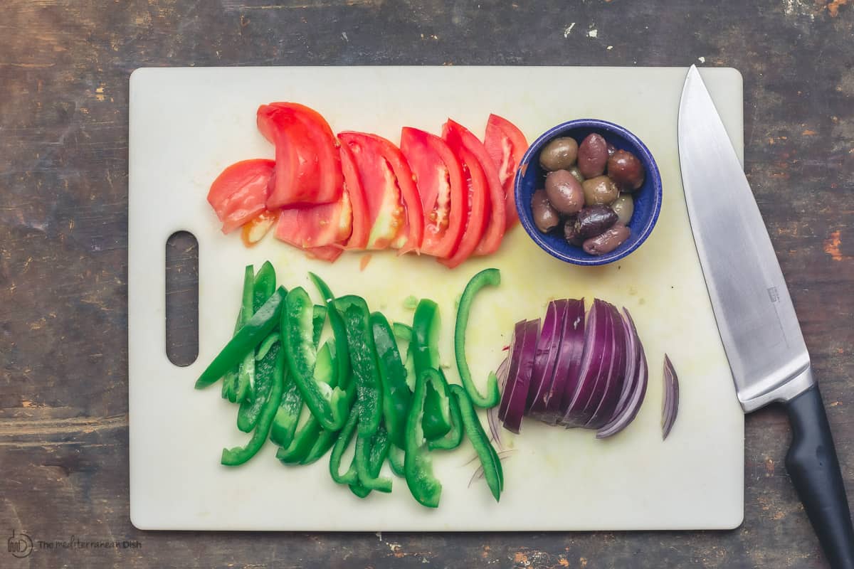 Toppings for chicken gyro, including tomatoes, green peppers, onions, and olives