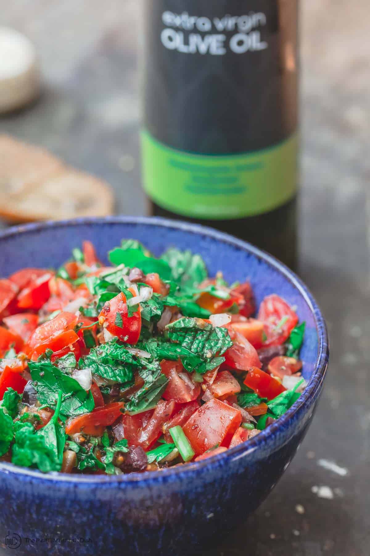 Homemade salsa served in a bowl with olive oil and pita chips