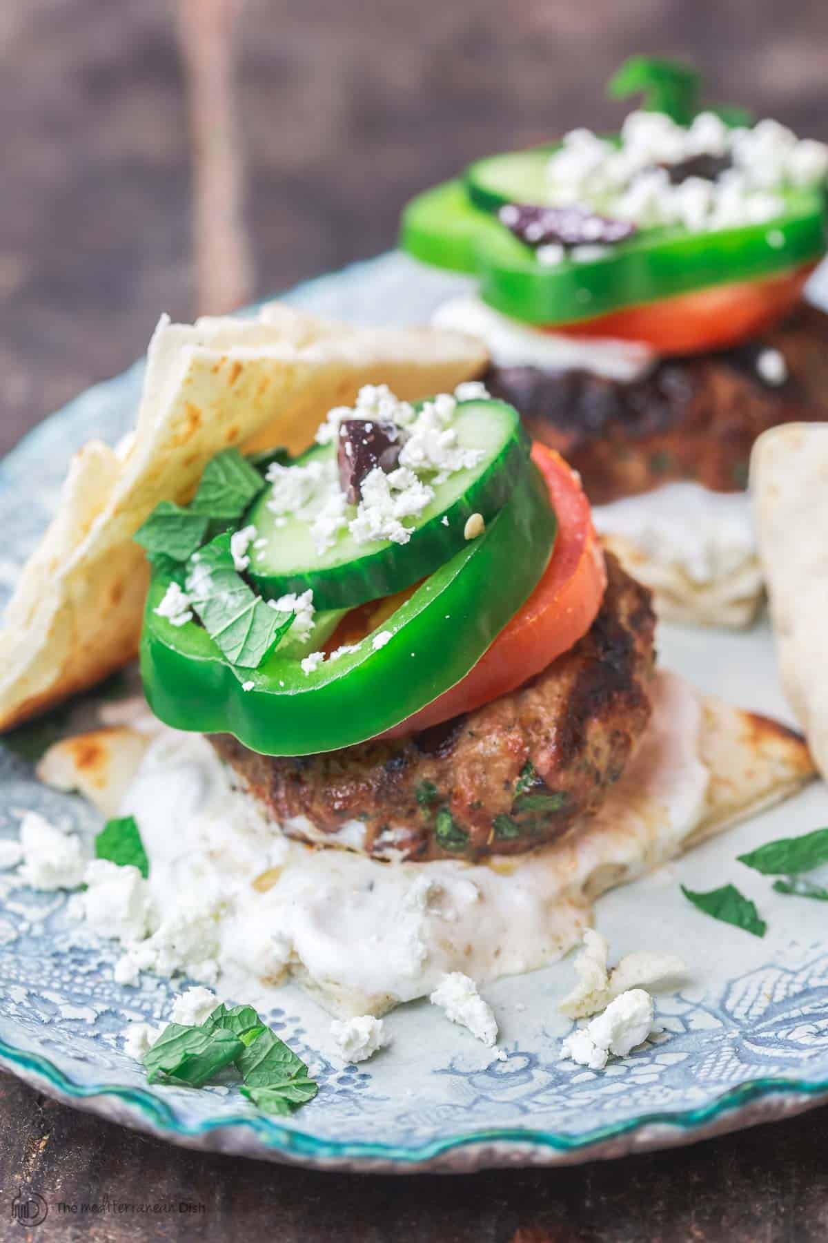 Greek lamb burgers with tzatziki sauce, vegetables, feta and olives