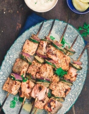 Mediterranean salmon kabobs served on a plate with tahini sauce