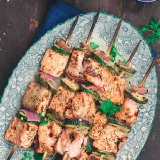 Mediterranean salmon kabobs served on a plate with tahini sauce