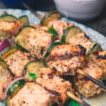 Grilled salmon kabobs stacked onto a serving plate