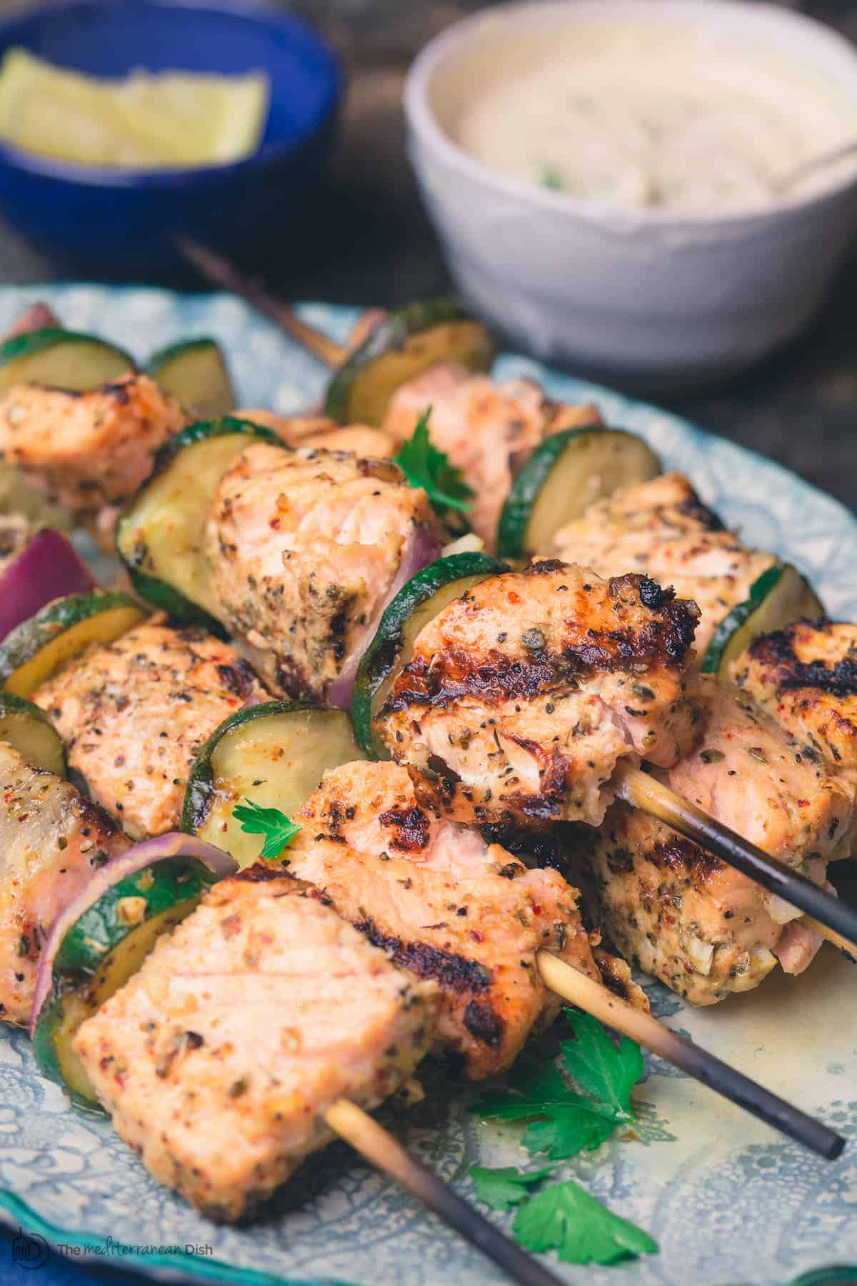 Grilled salmon kabobs stacked onto a serving plate