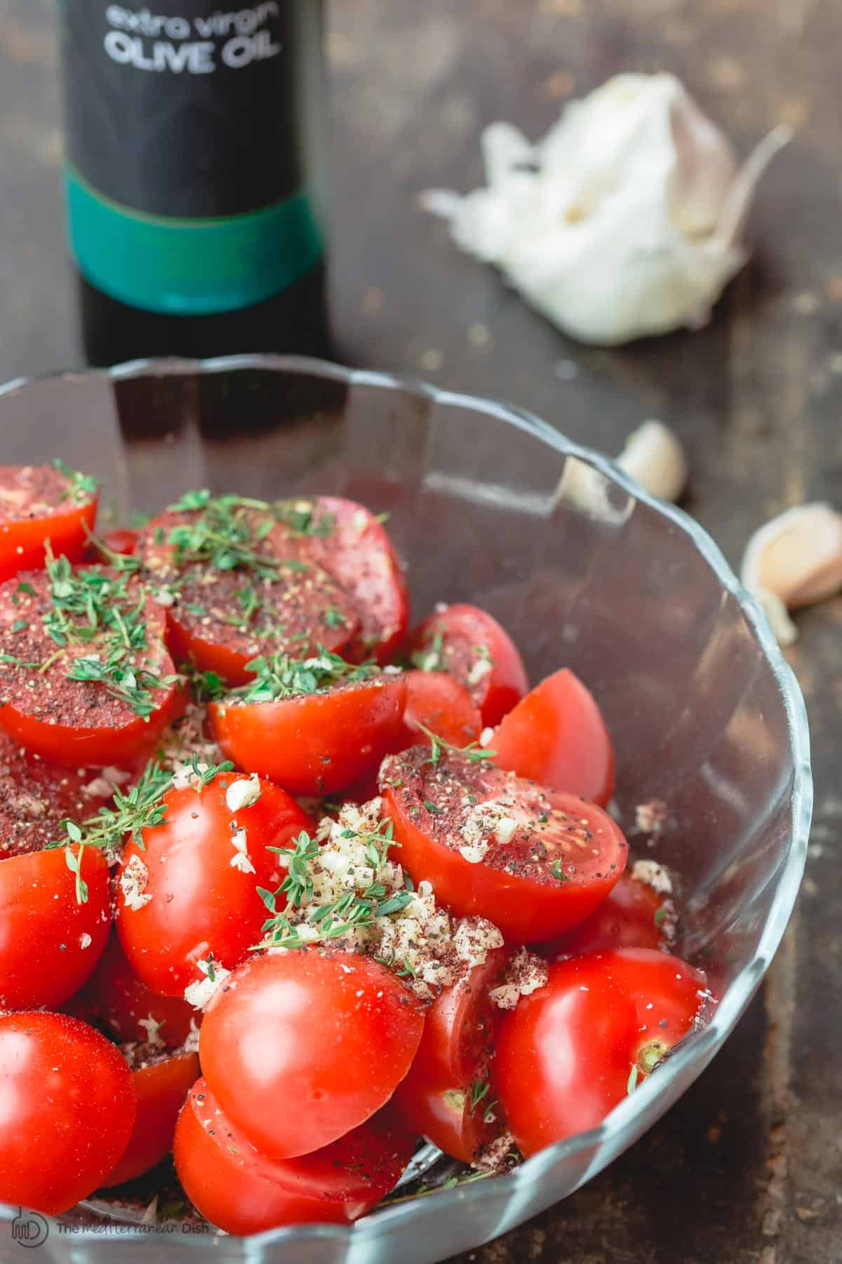 Tomatoes halved and seasoned and placed in mixing bowl