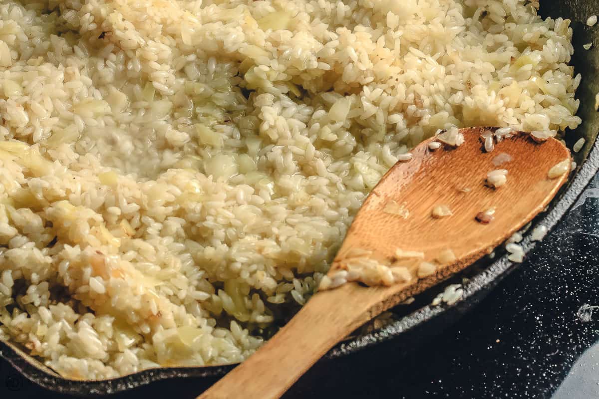 Cast iron skillet with rice being cooked