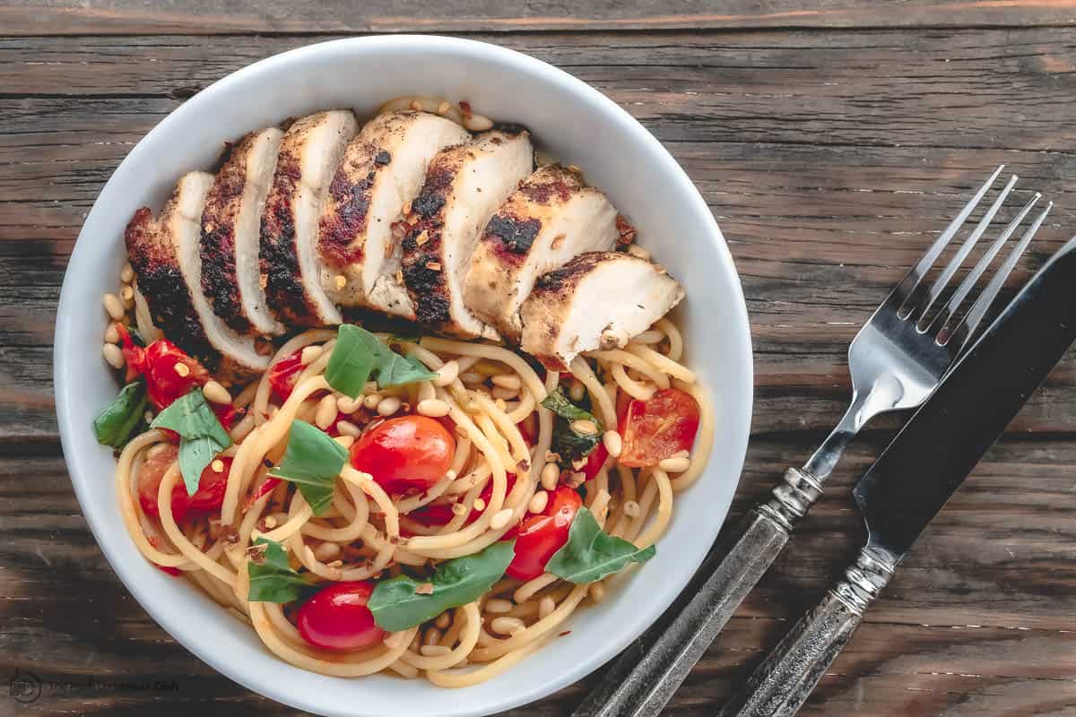 Chicken and spaghetti with tomatoes and basil served in a bowl