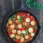 Scallops with tomatoes and bell peppers, sauteed in a cast iron skillet