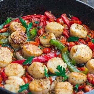 Scallops with vegetables in a cast iron skillet