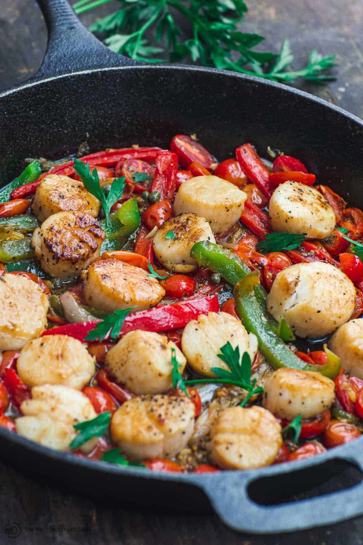 Scallops with vegetables in a cast iron skillet