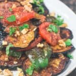 Slices of fried eggplant with mint, tomatoes, green peppers and walnuts