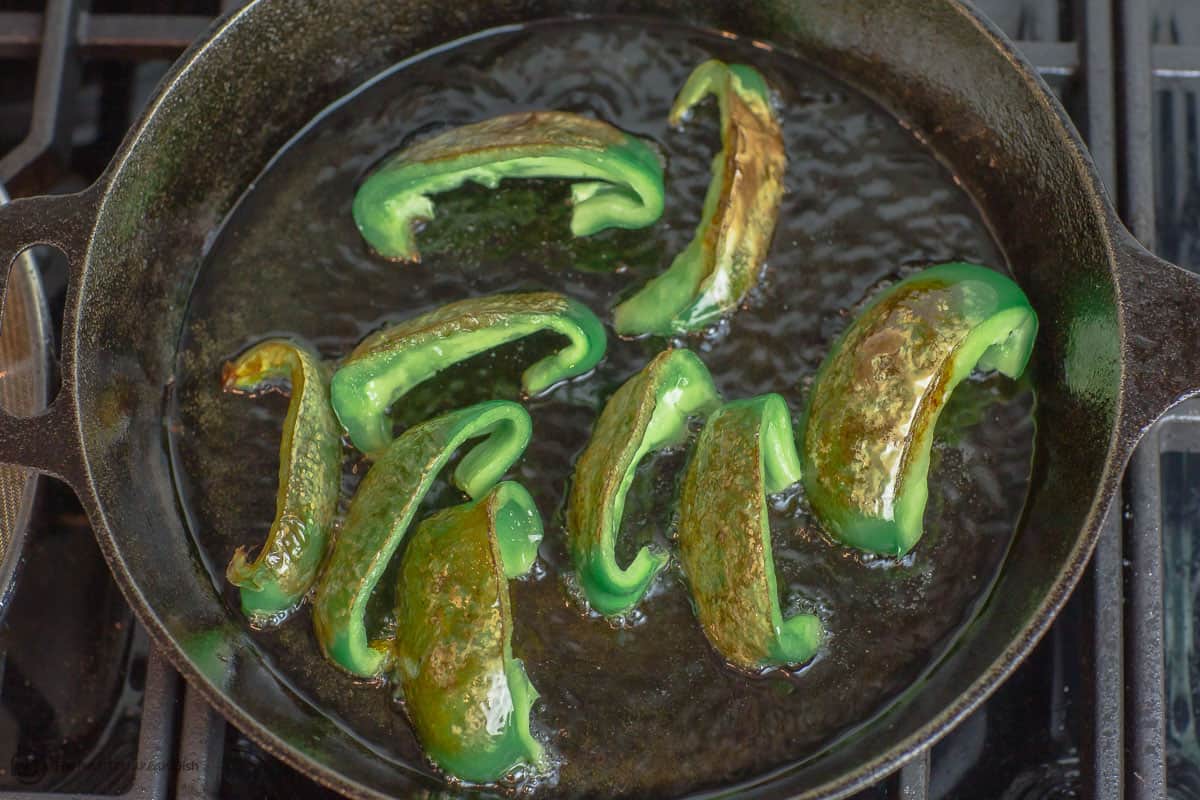 Green peppers fried in a cast iron pan