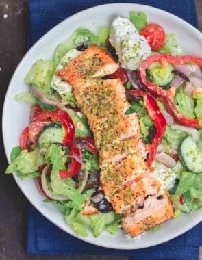 Salmon served on top of salad in a bowl
