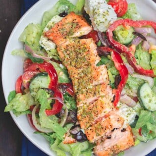 Salmon served on top of salad in a bowl