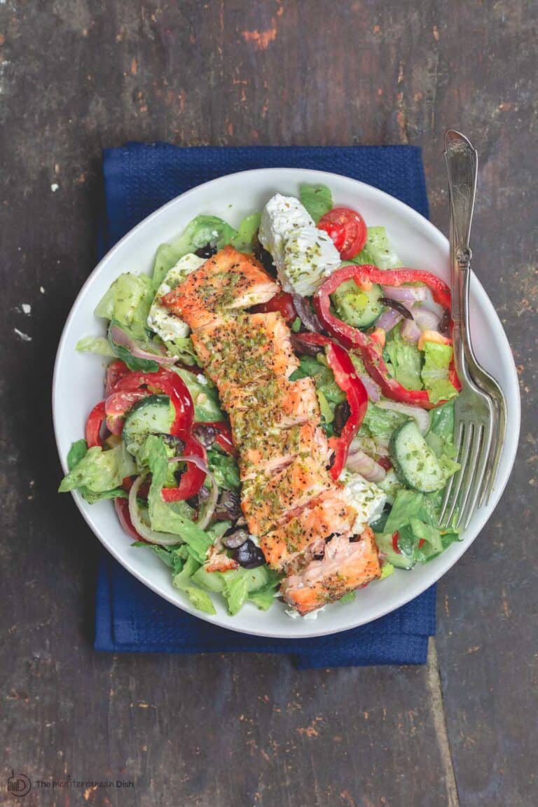 Salmon served on top of salad in a bowl