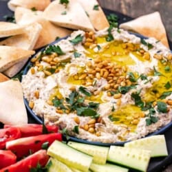 baba ganoush eggplant dip on a platter with vegetables and pita wedges