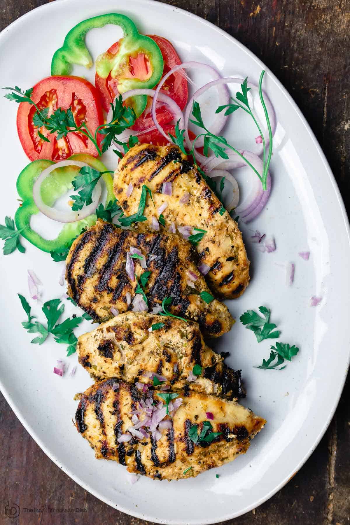 Grilled chicken breast on plate with vegetables