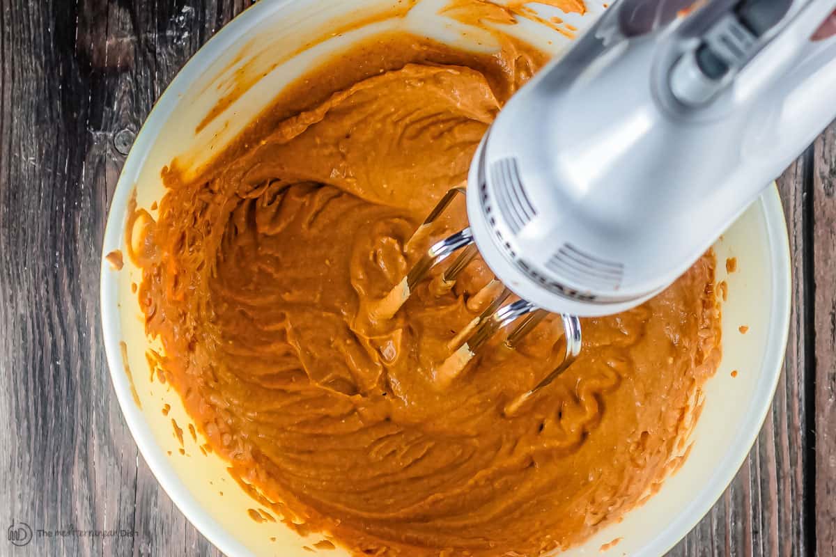 Pumpkin parfait ingredients being mixed using an electric hand mixer