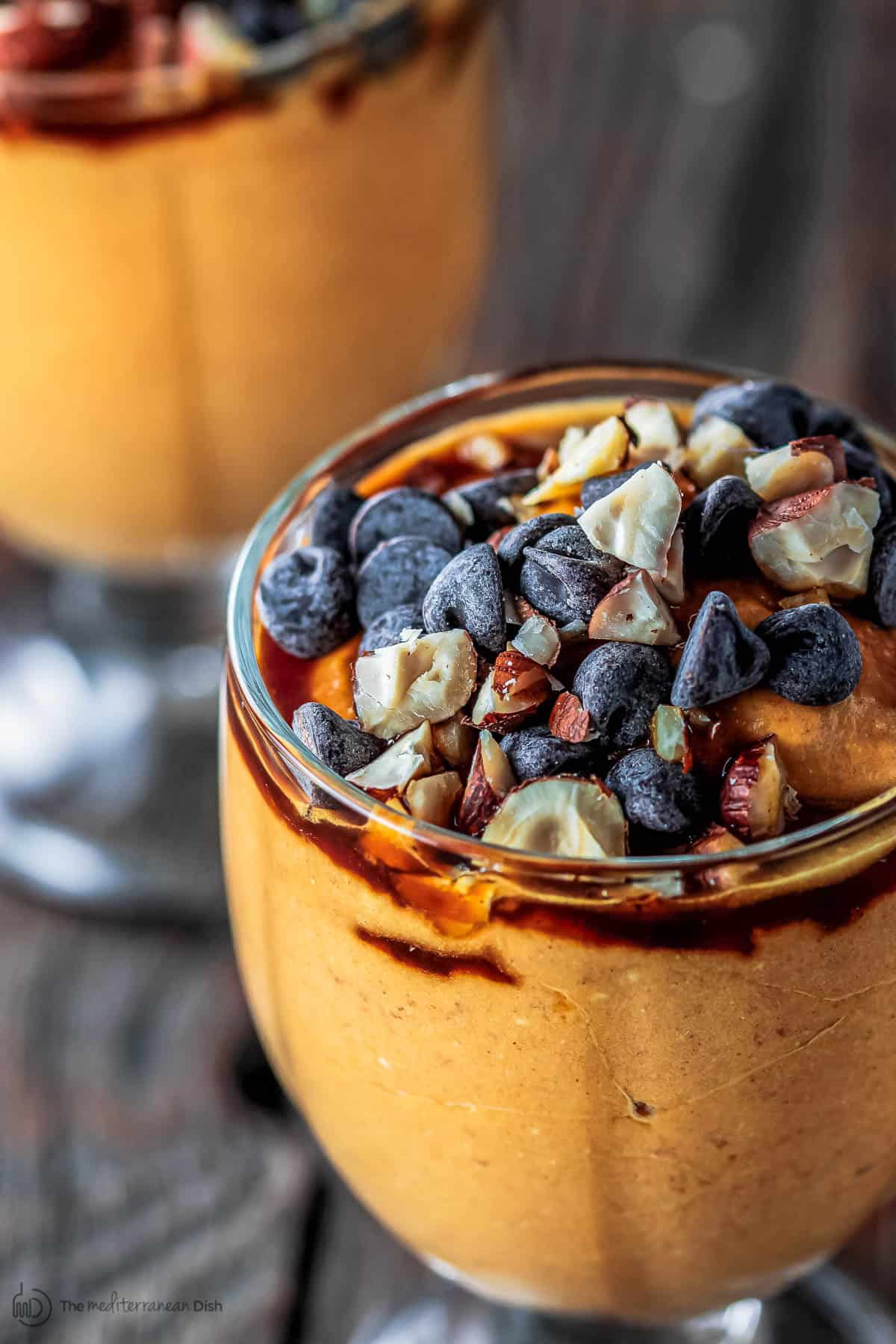 Pumpkin parfait served in goblets with chocolate chips and nuts