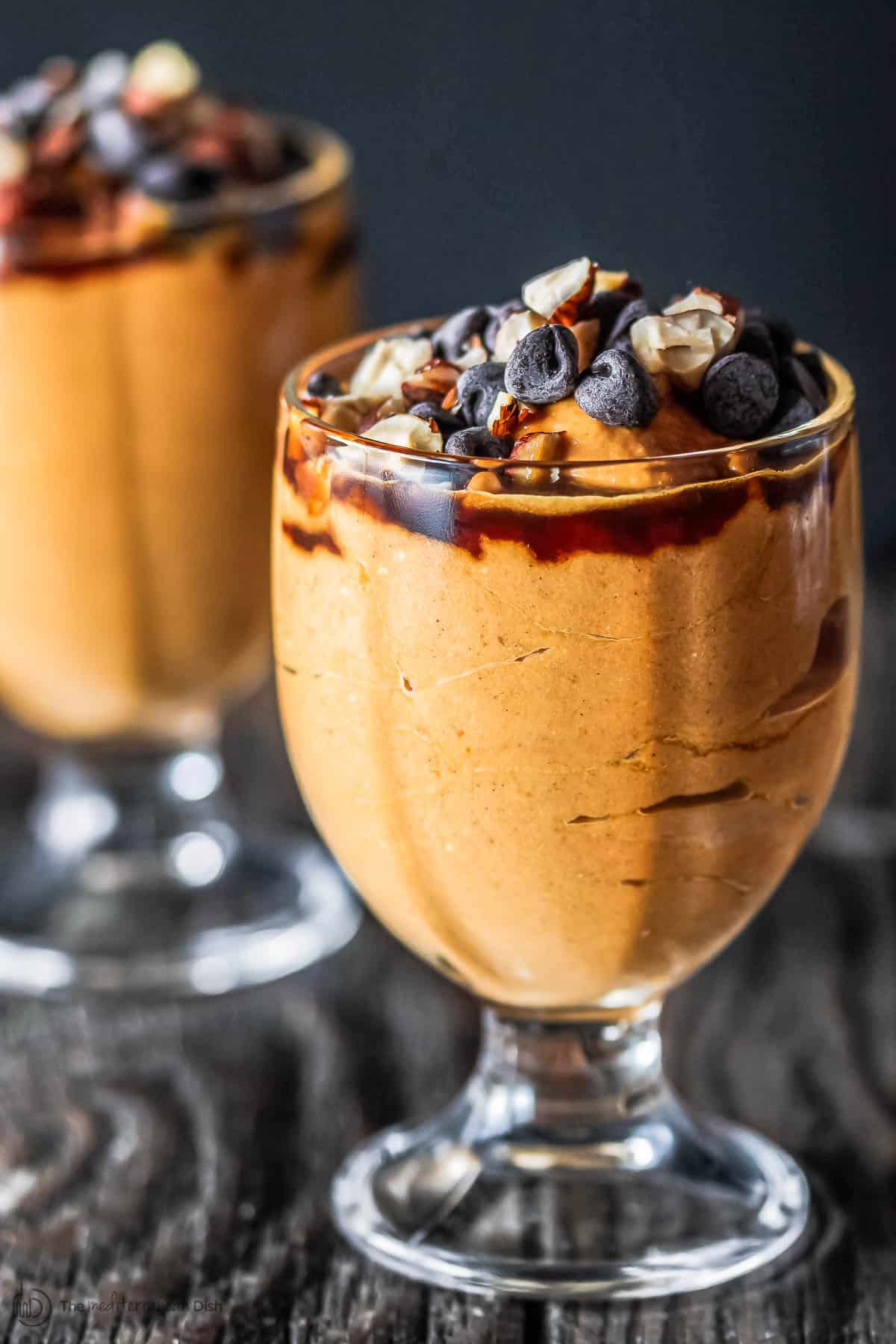 Pumpkin parfait served in small goblets, tipped with chocolate chips and nuts
