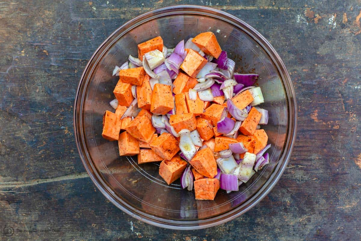 Freshly diced sweet potatoes and onions seasoned in mixing bowl