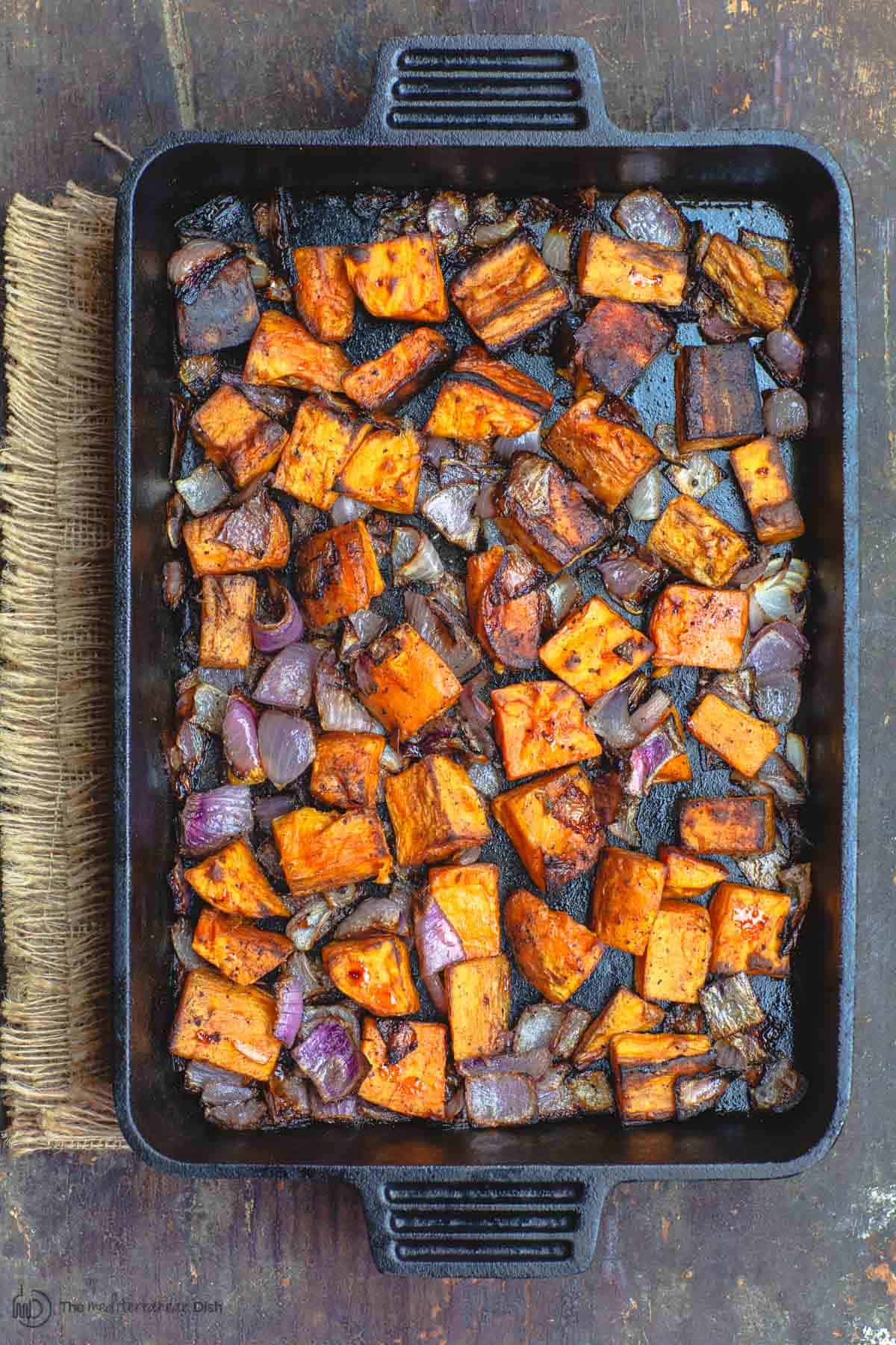 Diced sweet potatoes and onions roasted in pan