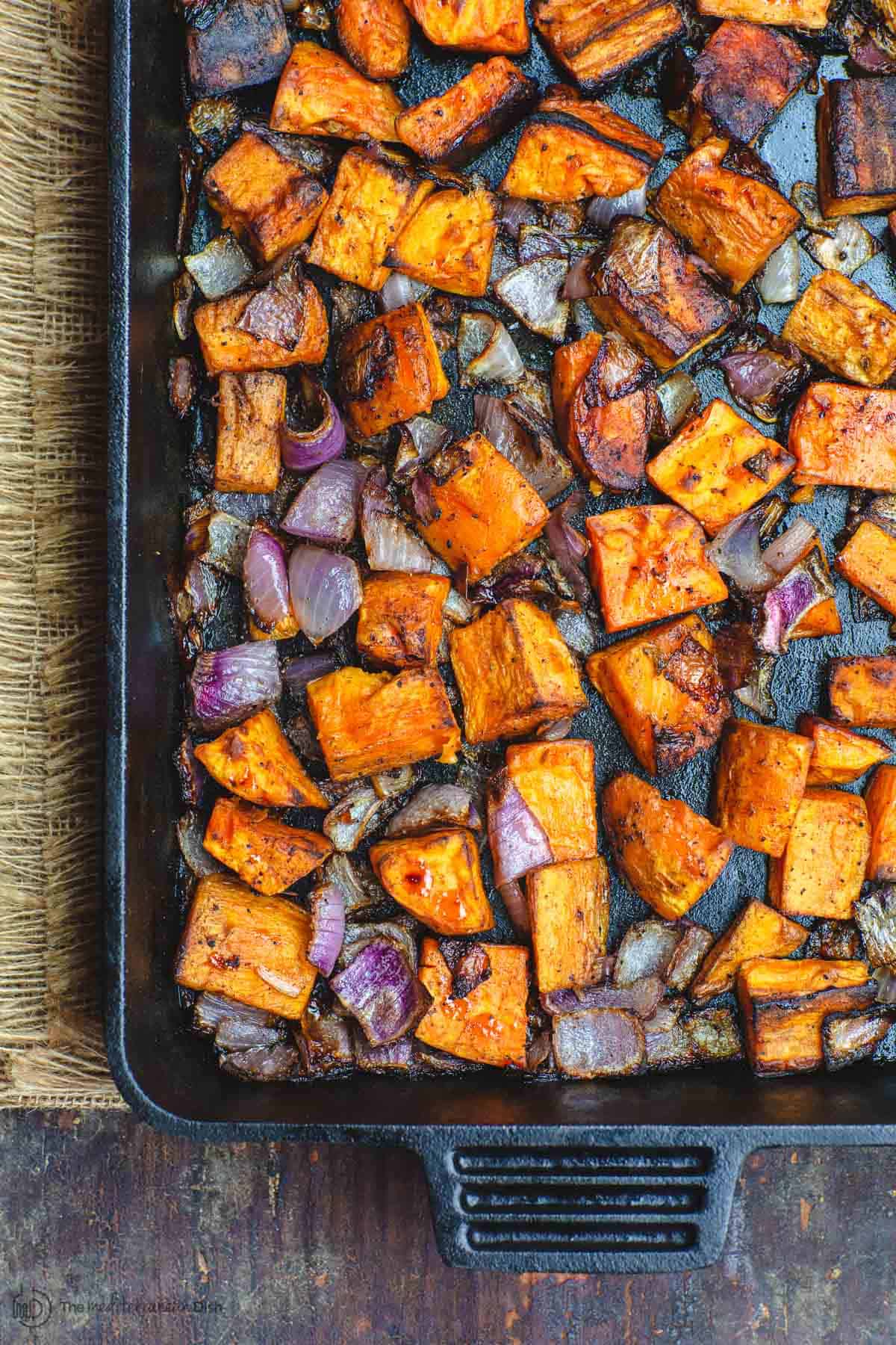 Diced sweet potatoes and onions roasted in cast iron pan