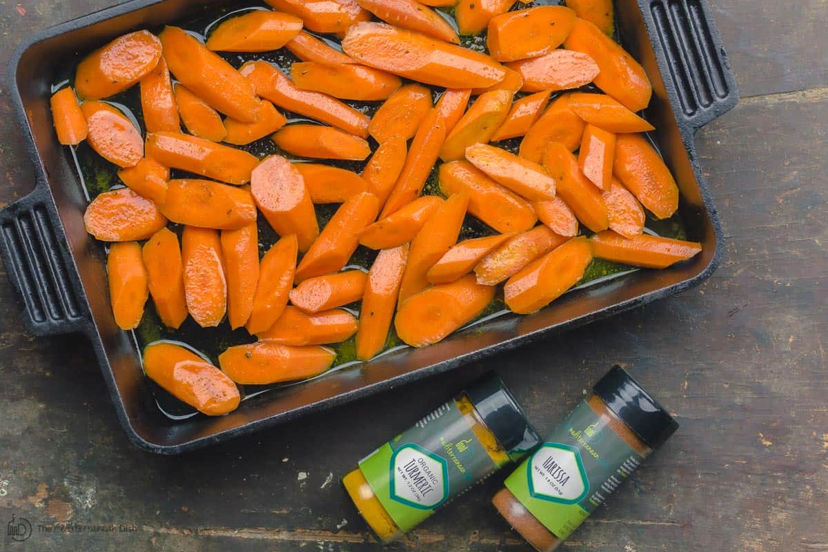 Sliced carrots in baking pan with spices