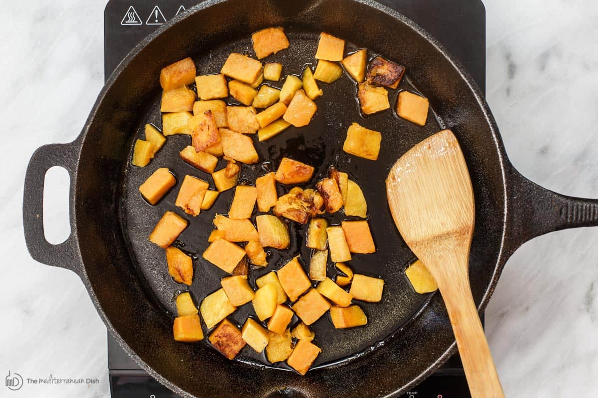 Butternut squash cubes cooking in pan