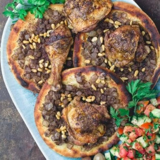 Musakhan sumac chicken over carmalized onion flatbread with side salad