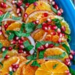 Orange Salad arranged on platter with pomegranate seeds, fresh mint, and onions