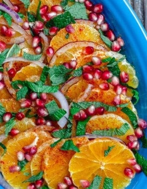 Orange Salad arranged on platter with pomegranate seeds, fresh mint, and onions