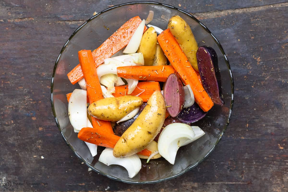 Carrots, potatoes and onions mixed with olive oil and spice mix