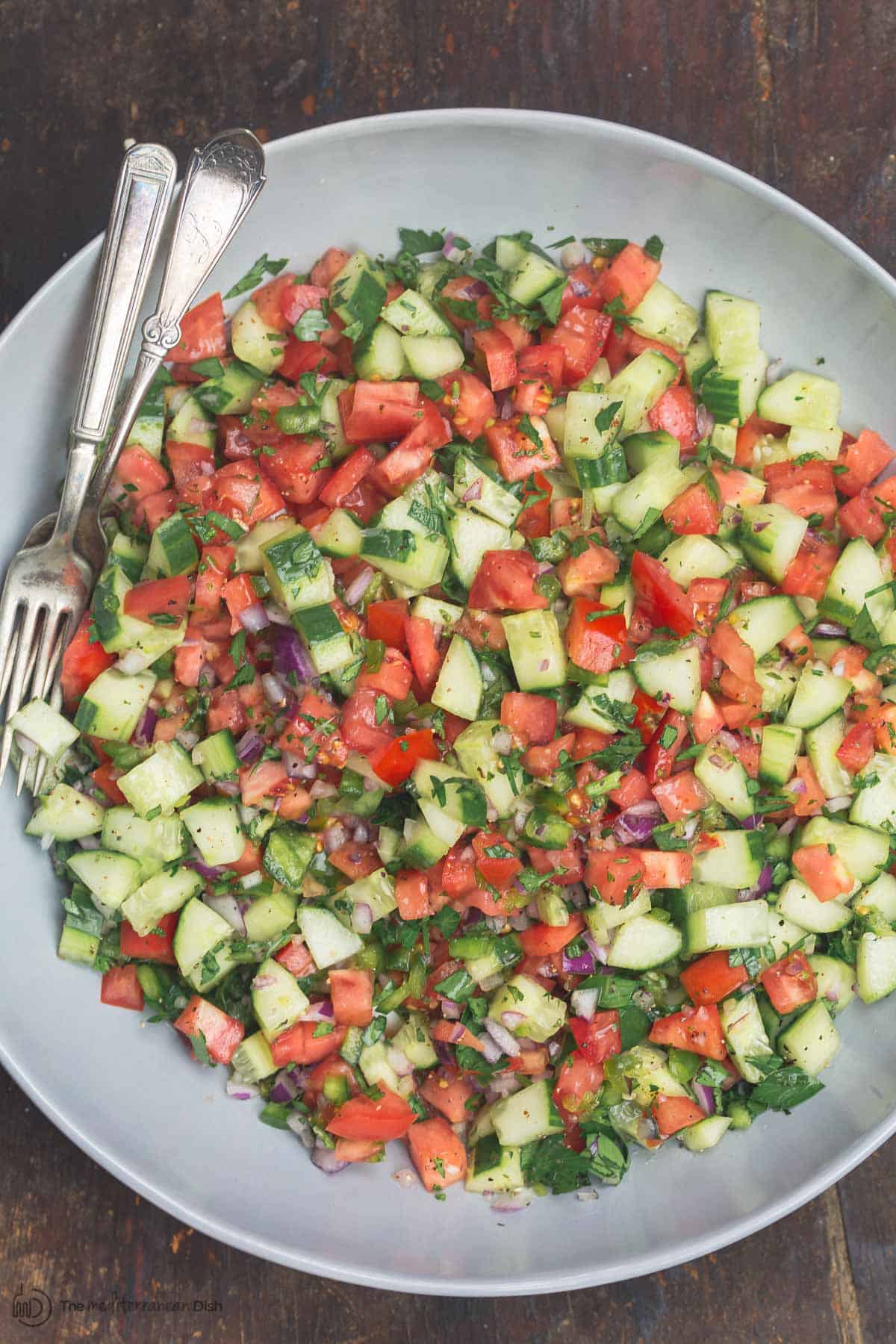 Mixed shiarzi salad with cucumbers, tomatoes, bell peppers, onions, and fresh herbs