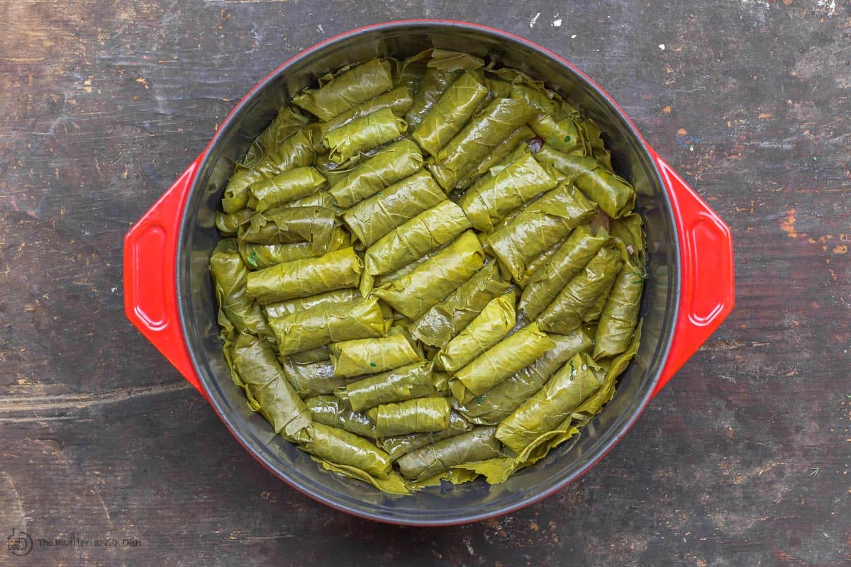 Uncooked stuffed grape leaves assembled in cooking pots