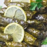 Stuffed Grape leaves on Serving Platter with Sliced lemons and a side of Tzatiki sauce