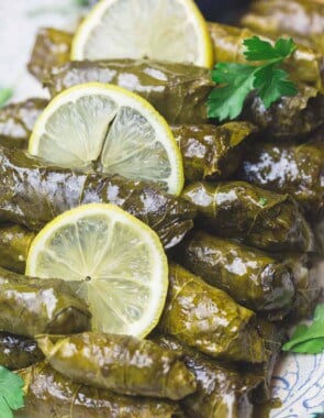 Stuffed Grape leaves on Serving Platter with Sliced lemons and a side of Tzatiki sauce