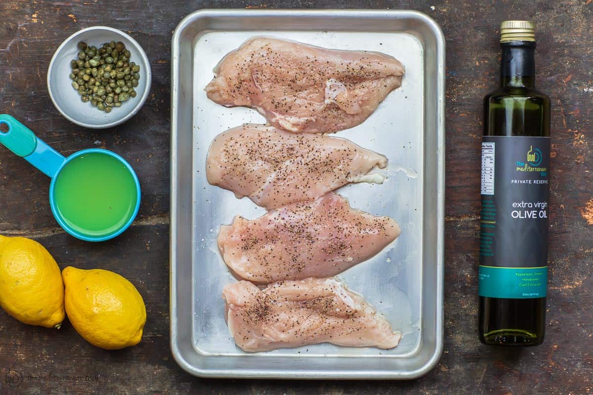 Ingredients for chicken piccata including chicken cutlets, extra virgin olive oil, lemons, capers, and ghee.