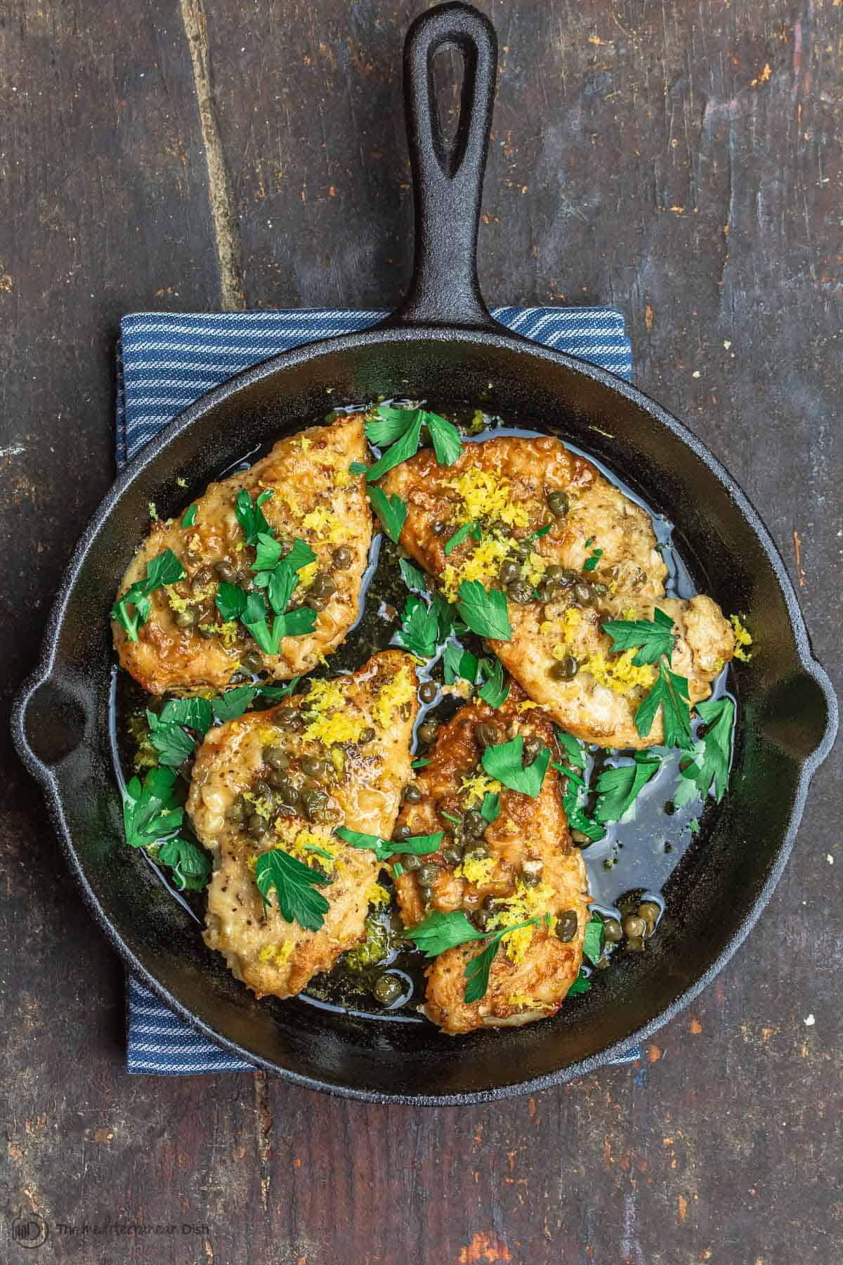 Cooked lemon chicken piccata in skillet ready to serve.