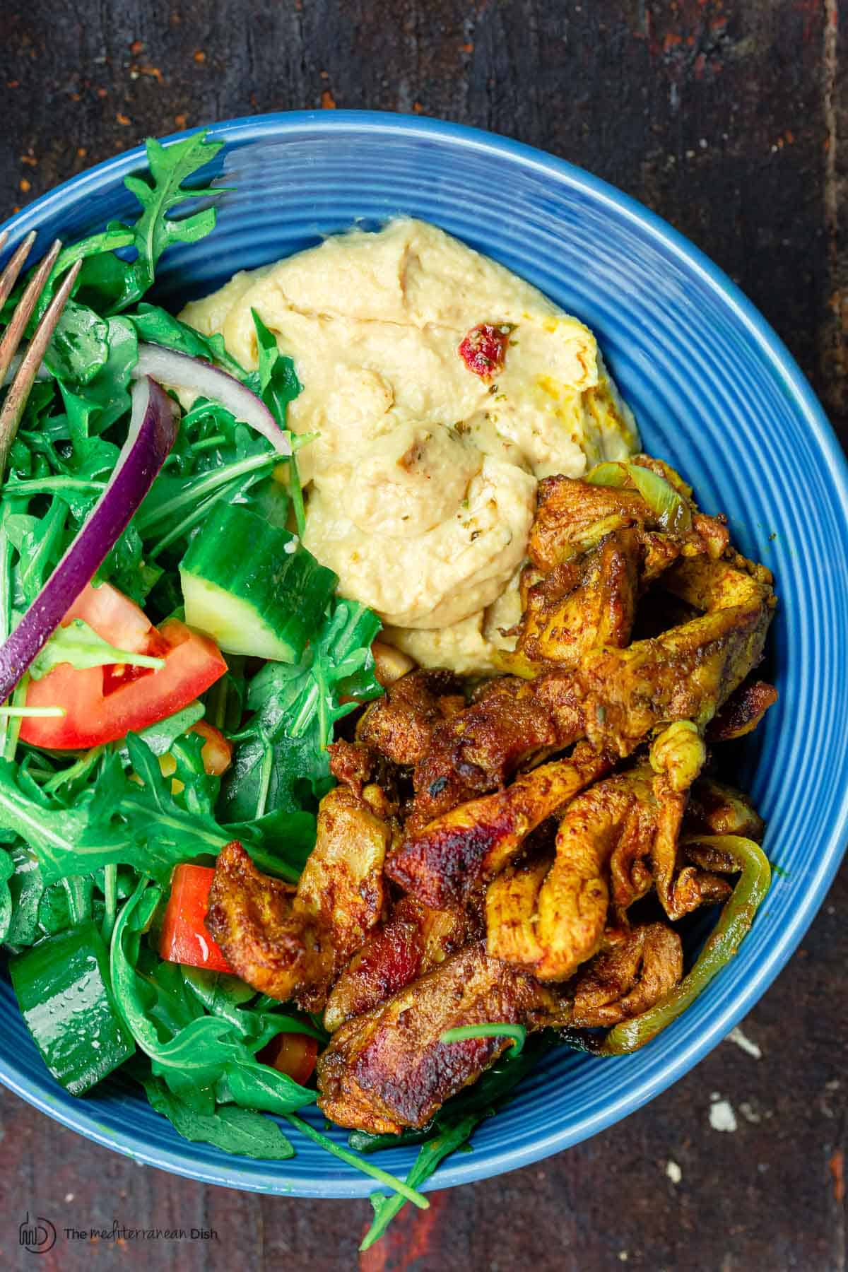 Chicken Shawarma Salad with arugula, tomatoes, and a side of hummus