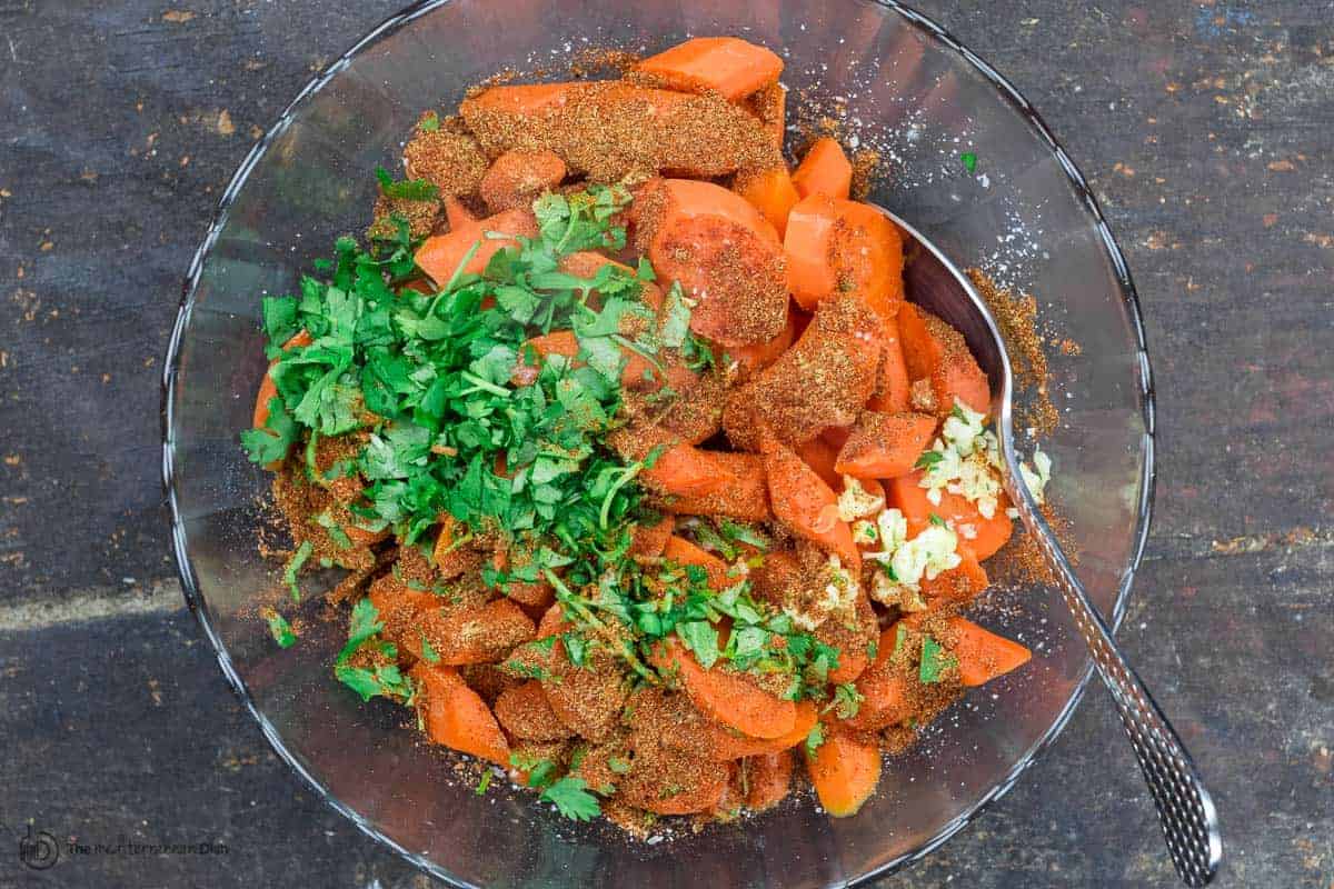 Carrots, cilantro, garlic, spices in one large mixing bowl to make carrot salad