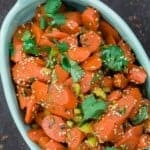 Moroccan carrot salad, garnished with fresh cilantro and toasted sesame seeds