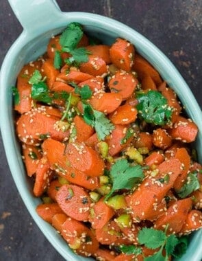 Moroccan carrot salad, garnished with fresh cilantro and toasted sesame seeds