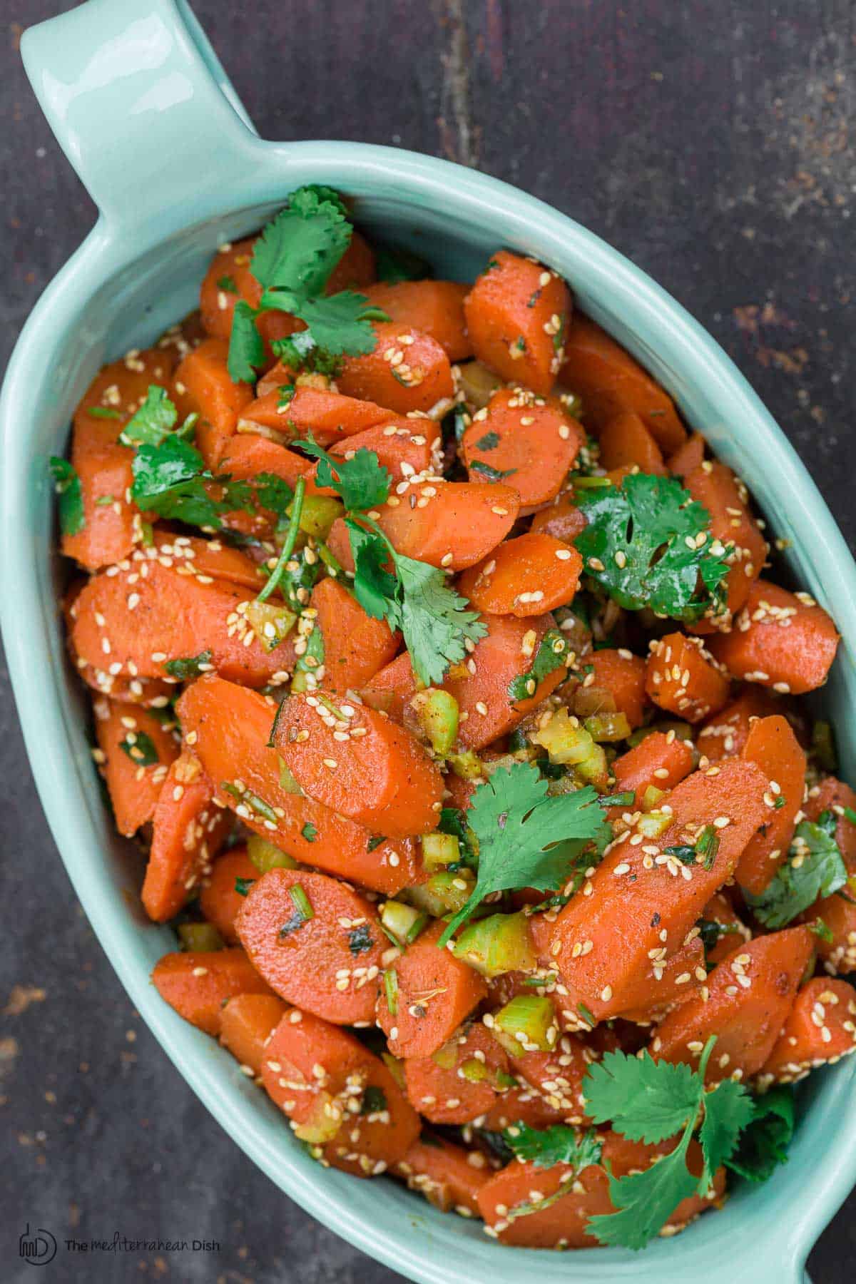 Moroccan carrot salad, garnished with fresh cilantro and toasted sesame seeds