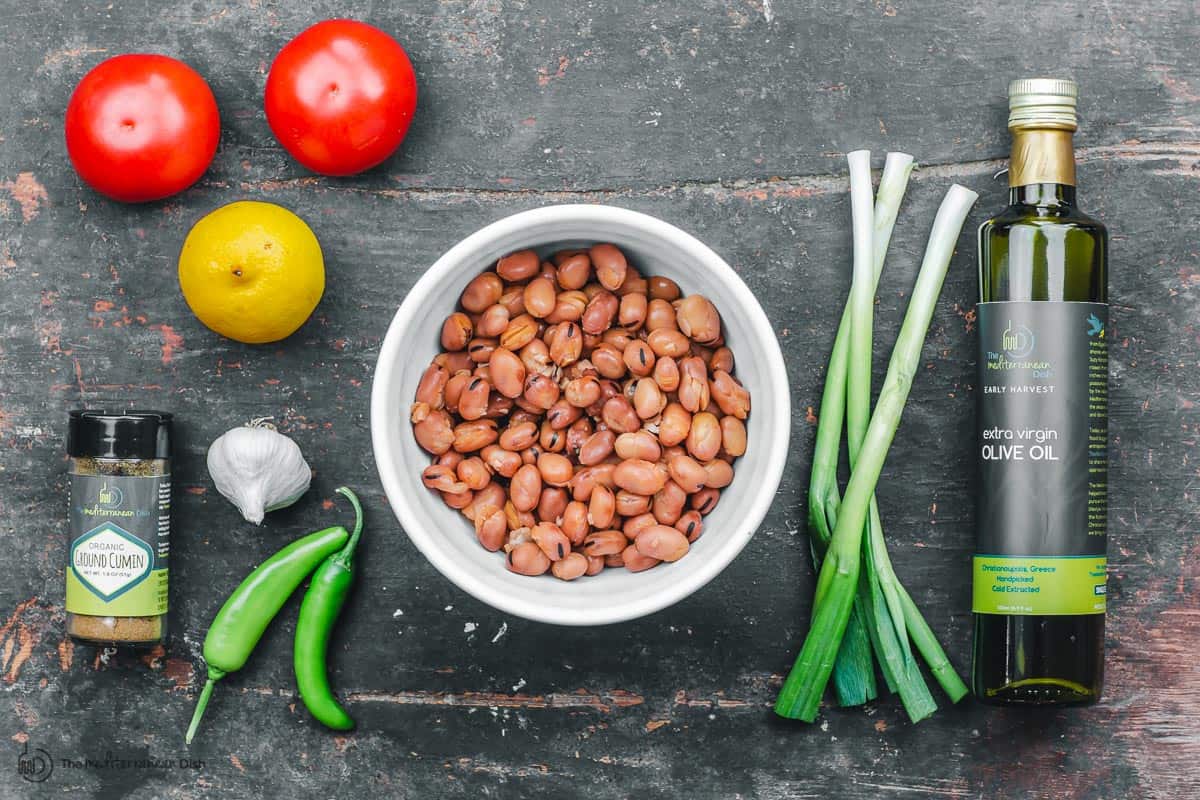 Ingredients for foul mudammas. fava beans, tomatoes, peppers, lemon juice, olive oil, garlic and cumin