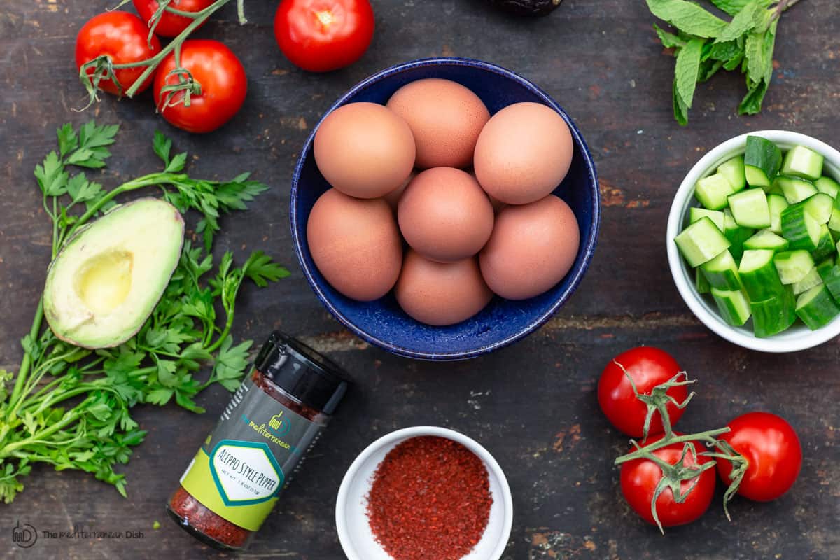 Ingredients for healthy egg salad, Mediterranean-style. Eggs, avocados, tomatoes, cucumbers and fresh herbs