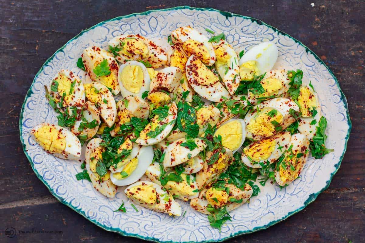 Seasoned eggs with fresh herbs on serving platter